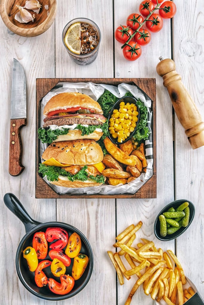 A mouth-watering gourmet burger meal with fries, peppers, and corn, perfect for a delicious dining experience.